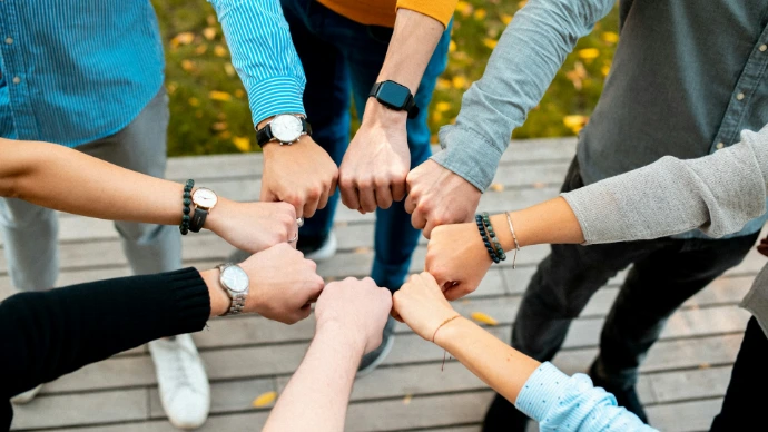 A group of people putting their hands together